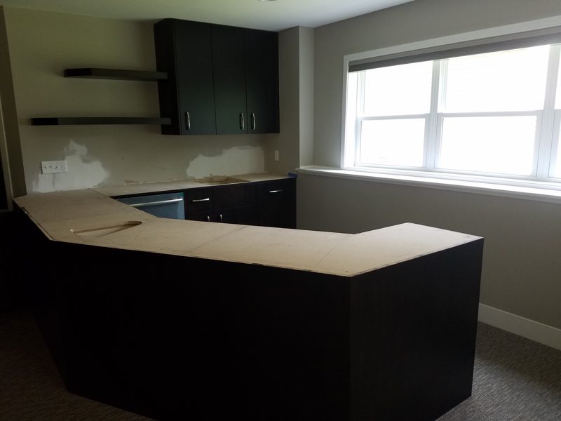 Dark wood bar with an L-shaped counter and floating shelves