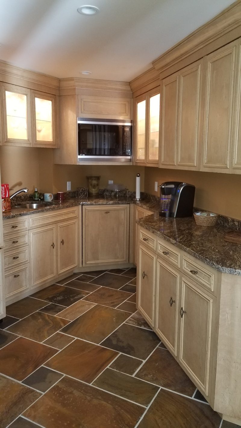 Light painted bar kitchen with granite counters and glass-front upper cabinets