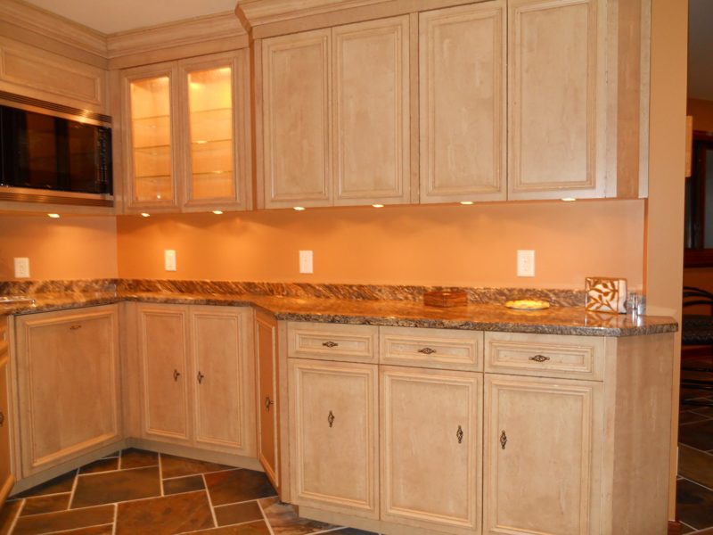 Cream bar cabinets with under-cabinet lighting and granite counters