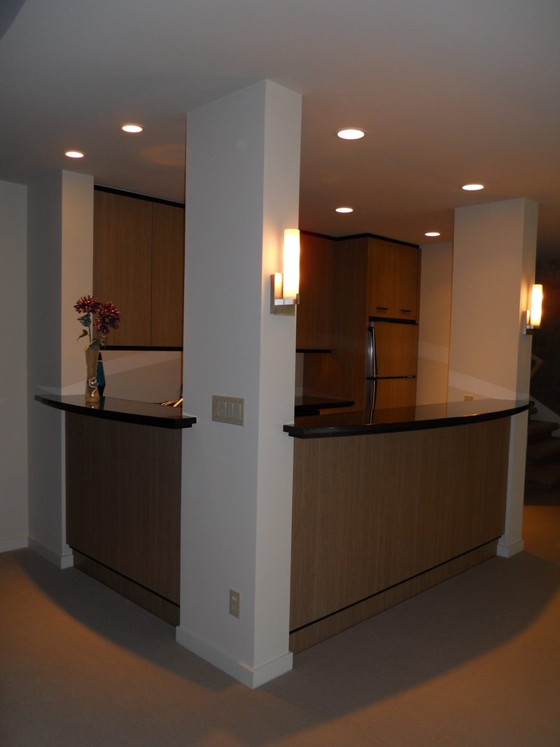 Wood-paneled bar with a dark counter between white columns