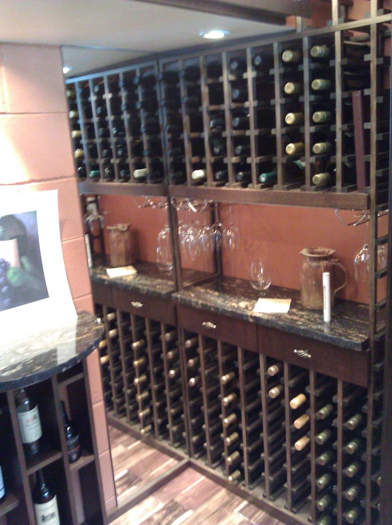 Dark wood wine racks above a stone-topped tasting counter