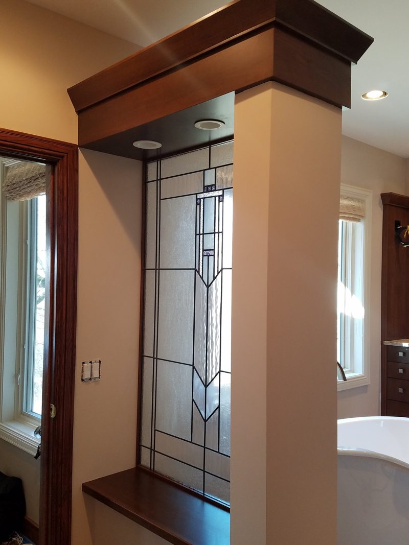 Tall dark wood column with a leaded glass panel and crown molding