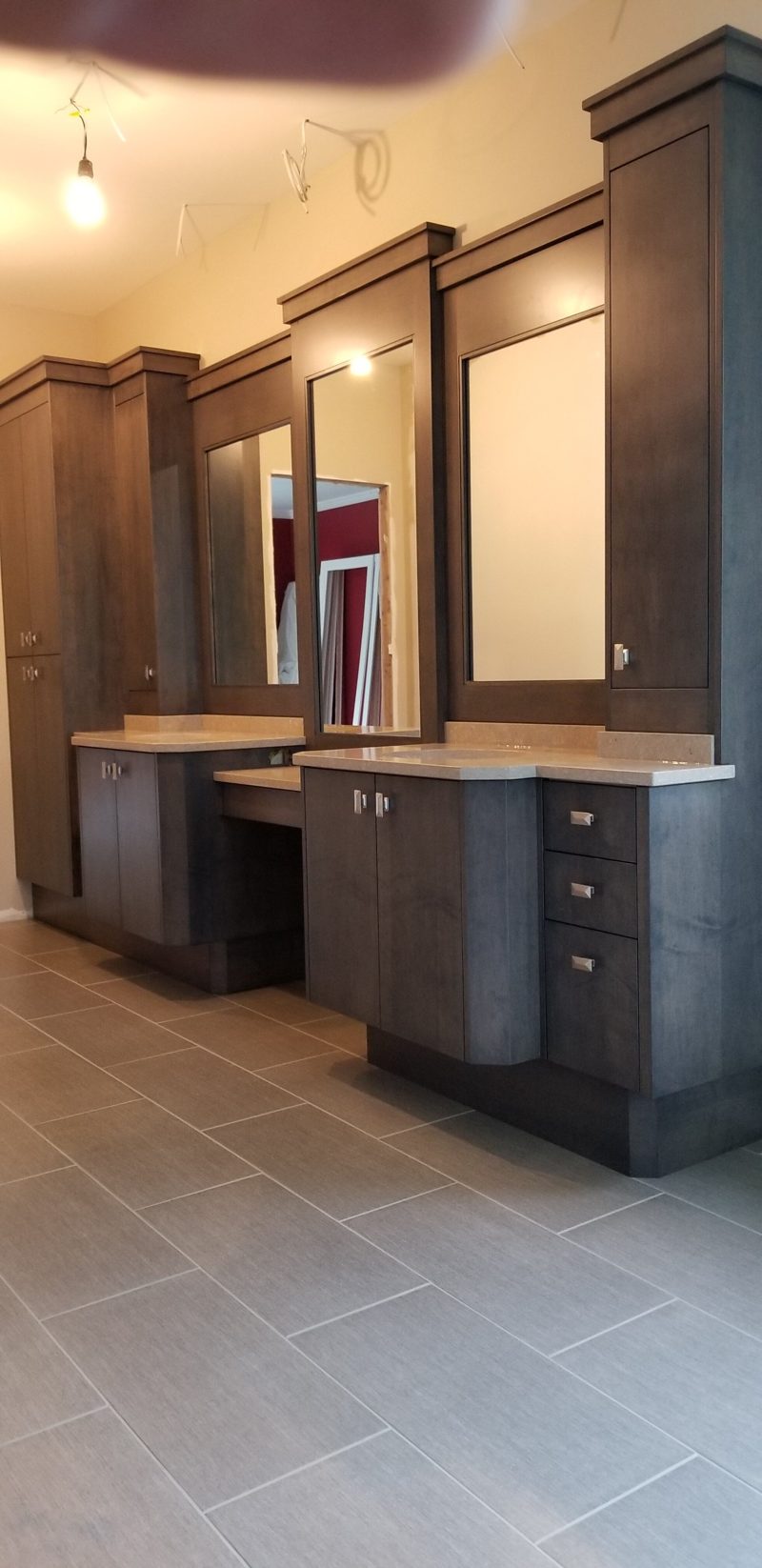 Gray double vanity with a makeup desk, tall mirrored towers, and tile floor