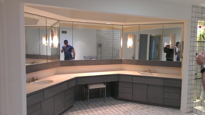 Long wraparound gray vanity with a knee-space desk and full wall mirror