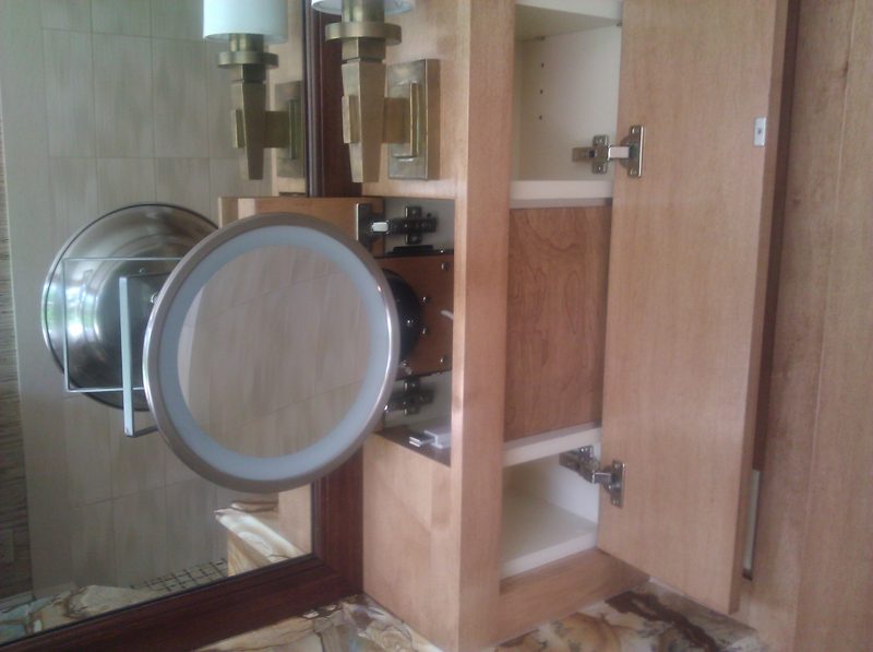 Open light wood medicine cabinet with a magnifying mirror and inner shelves