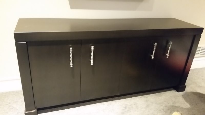 Front view of a dark gray media cabinet with four doors and bar pulls