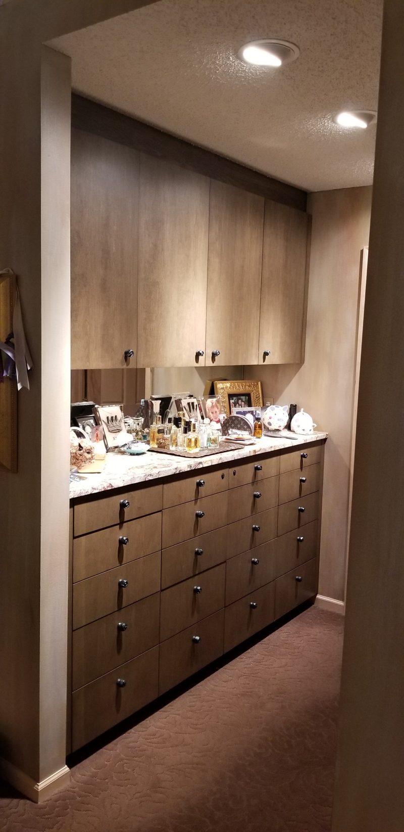 Tall built-in wood cabinets and a drawer bank with a light countertop