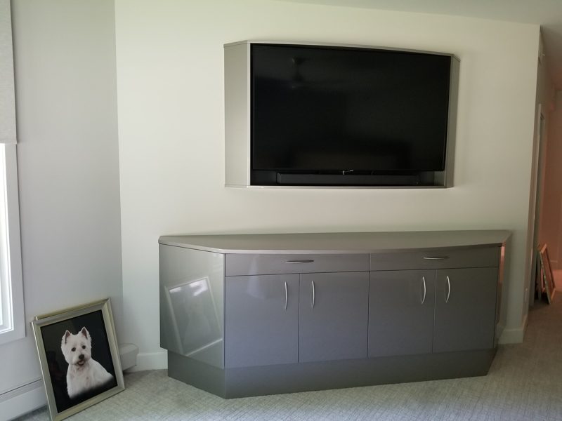 Gray metallic media cabinet below a framed wall-mounted TV