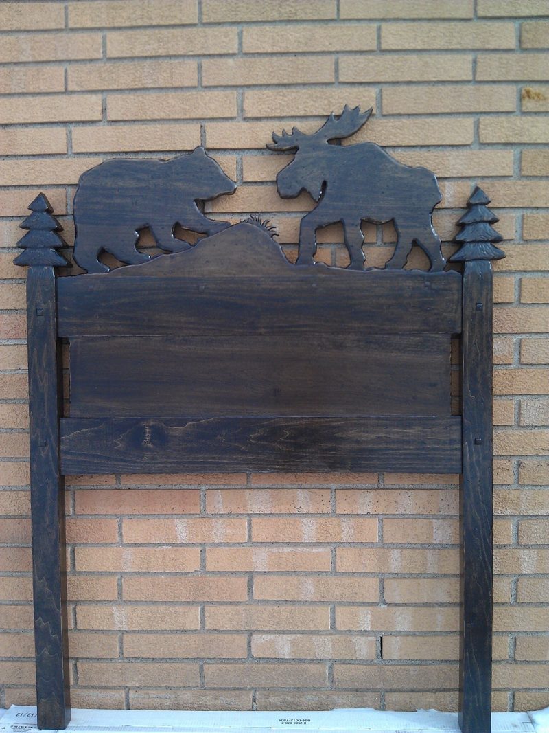 Dark wood twin headboard with bear, moose, and pine tree cutouts
