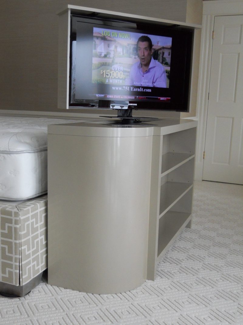 Gray TV lift cabinet with open side shelves and the TV raised