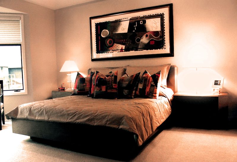 Dark platform bed with patterned pillows and matching nightstands