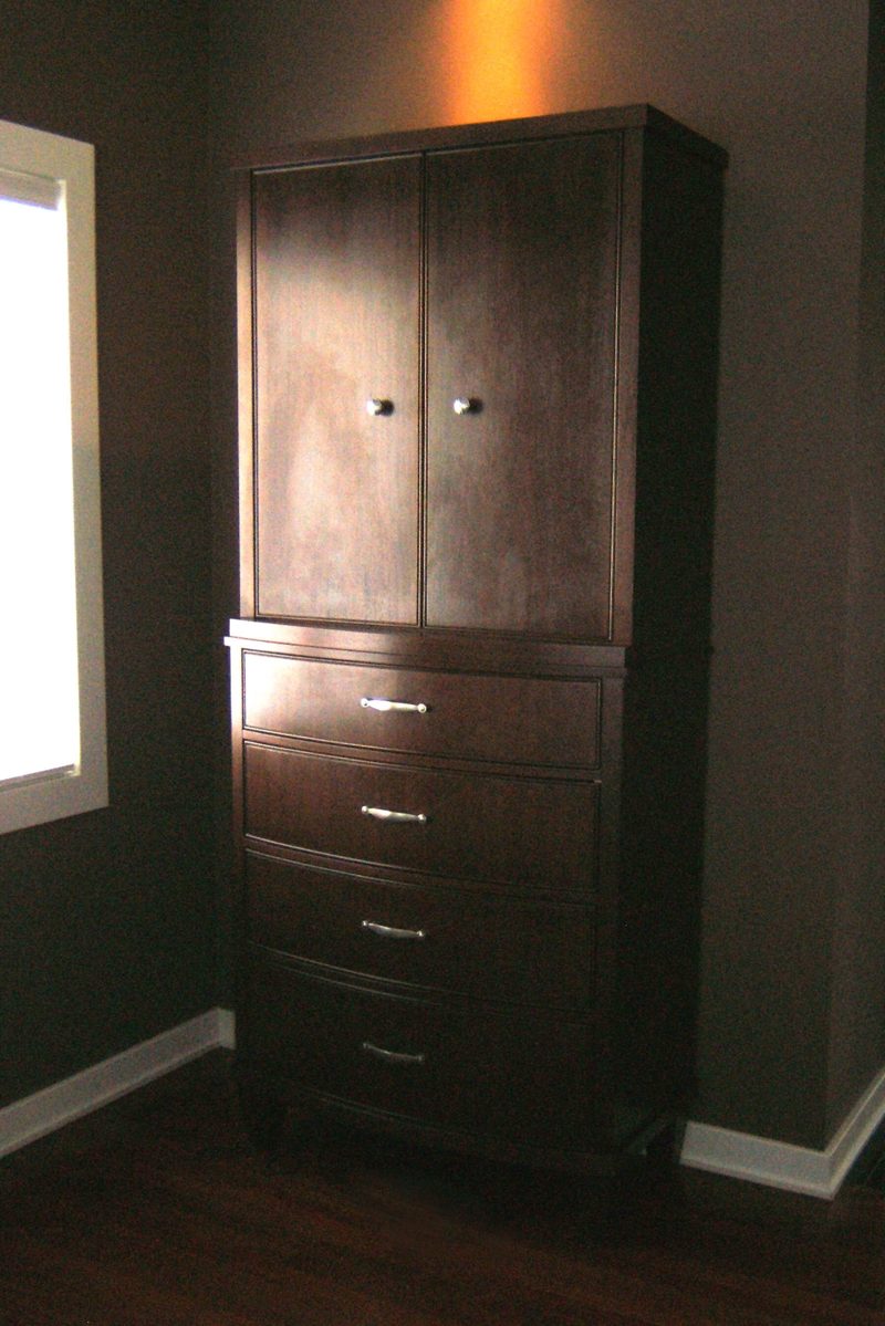 Tall dark wood armoire with upper doors and a stack of drawers