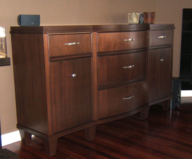 Dark wood bow-front dresser with drawers and doors on tapered feet