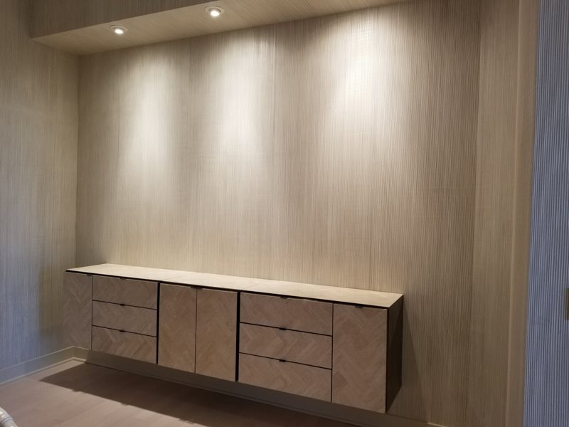 Paneled dining nook with a floating wood buffet under recessed lighting