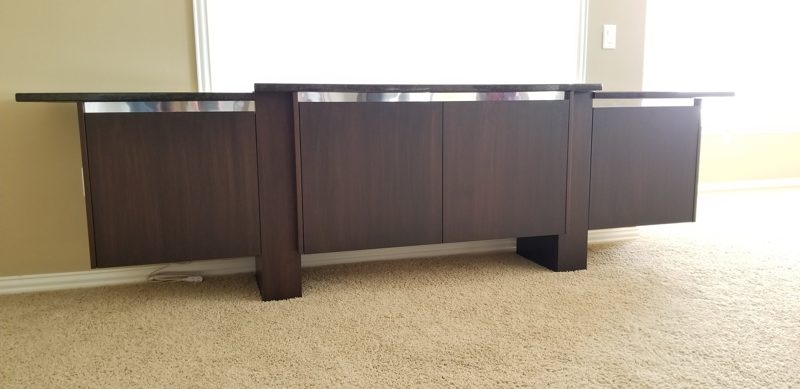 Front view of a dark wood buffet with a stepped black top