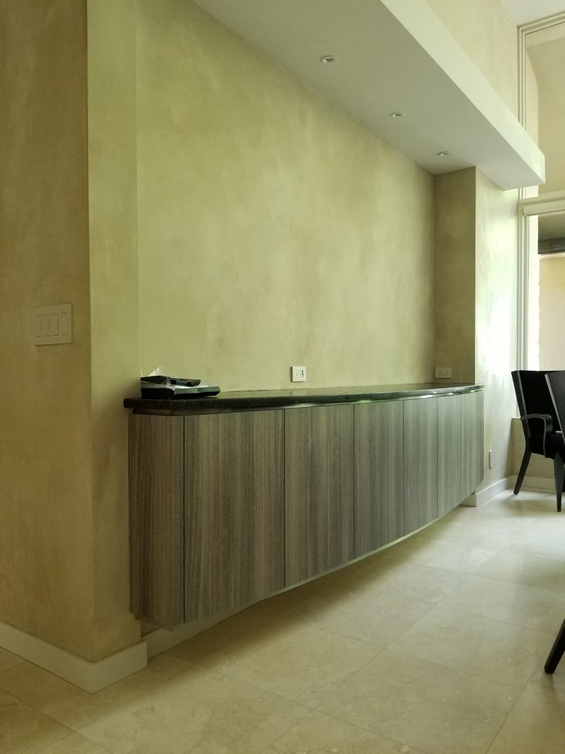 Curved floating gray wood-grain buffet with a black stone top