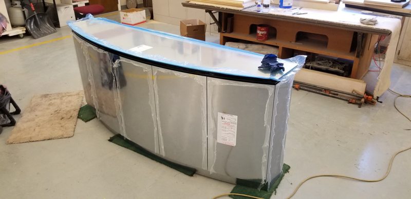 Curved stainless steel buffet body with a glass top in the workshop