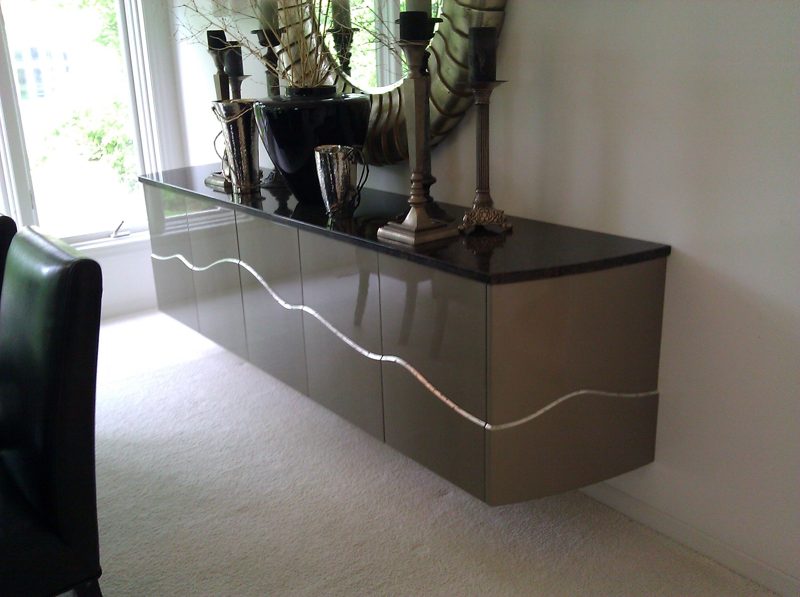 Floating taupe sideboard with a wavy metal inlay and dark stone top