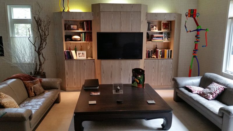 Living room with a gray wood-grain entertainment wall, sofas, and a coffee table