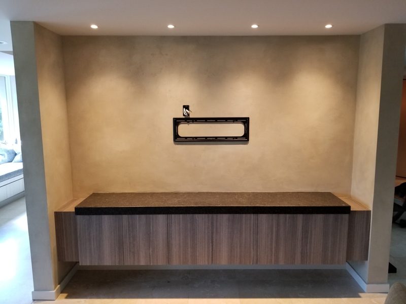 Floating gray wood-grain console with a dark top in a lit wall recess