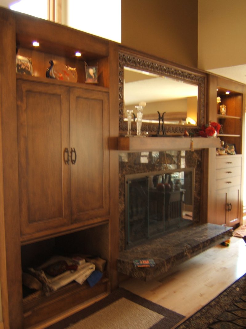 Side view of dark wood fireplace built-ins with a firewood niche