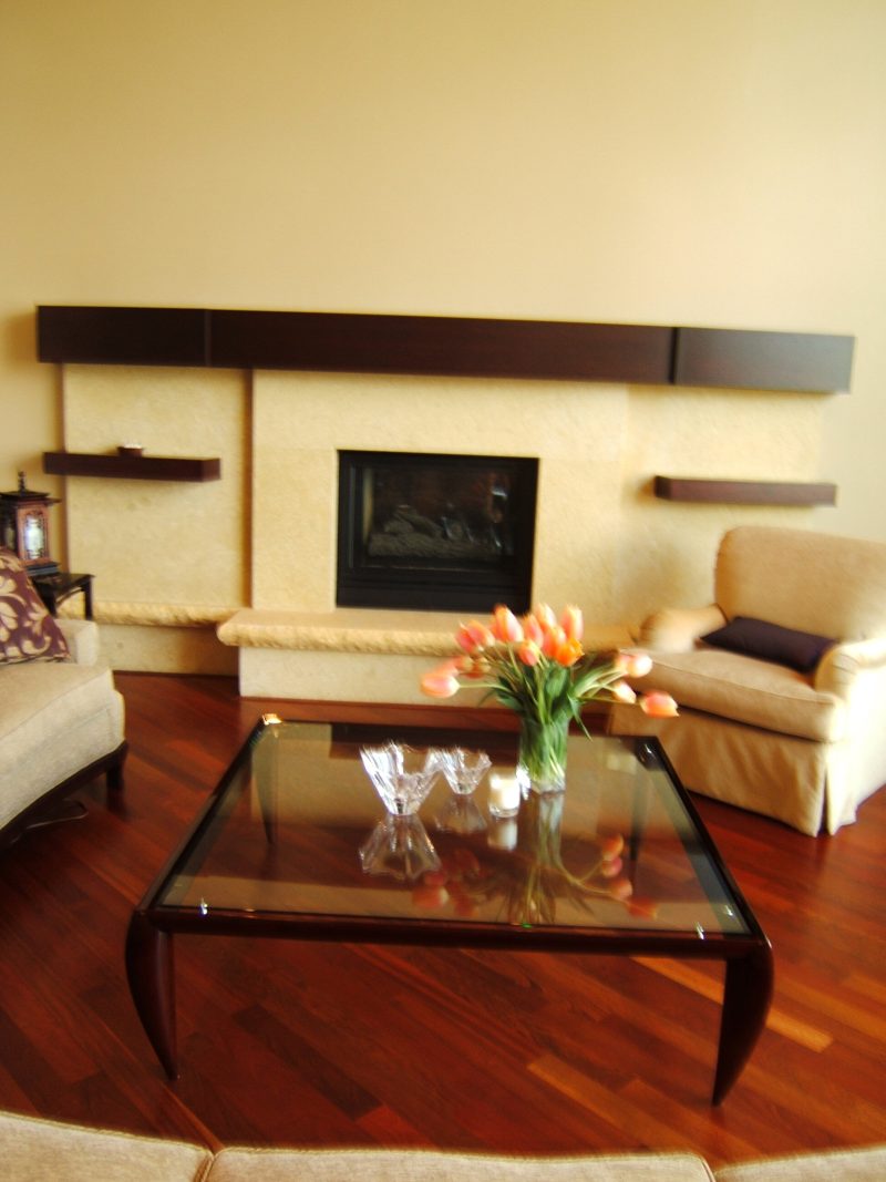 Dark wood floating shelves above a cream fireplace surround