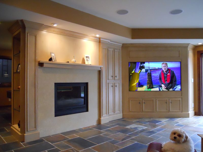 Cream painted built-ins with a fireplace, TV, and lit display niches