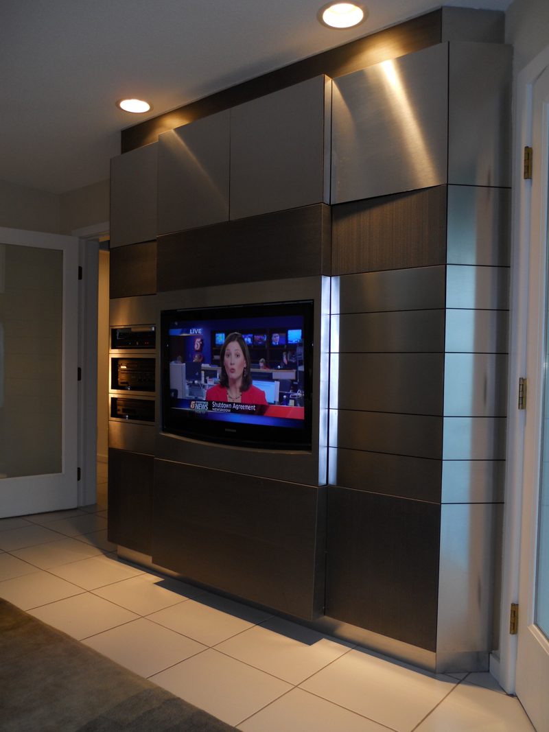Tall dark metal-finish media cabinet with a TV and steel trim