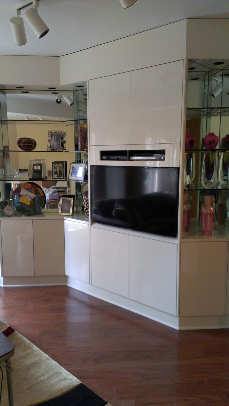 Glossy white tall cabinet with a TV niche beside glass display shelves