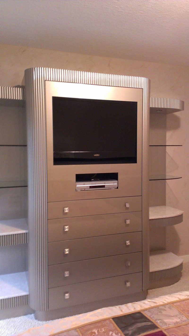 Silver TV cabinet with a stack of drawers and curved side shelves
