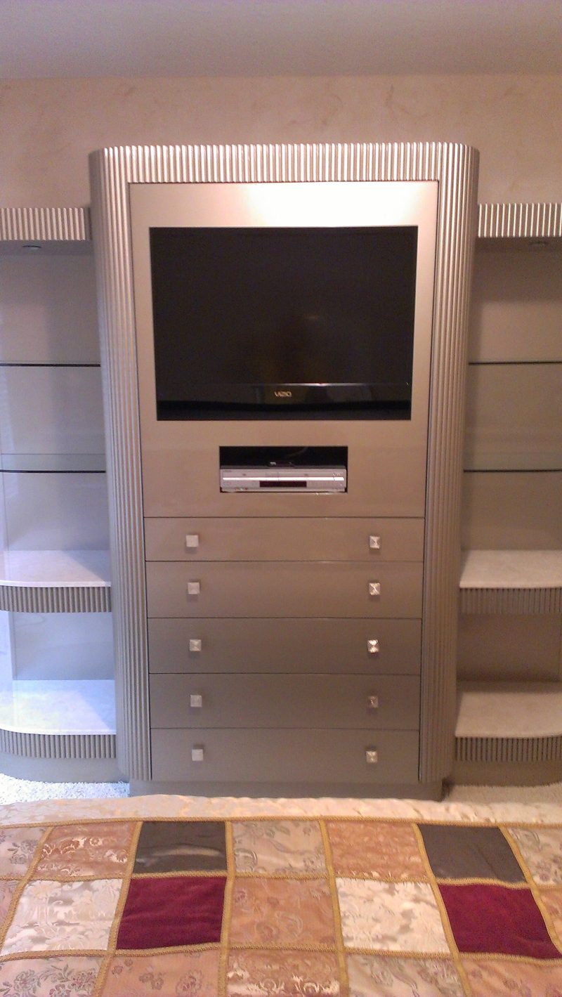 Front view of a silver TV cabinet with drawers and curved glass side shelves