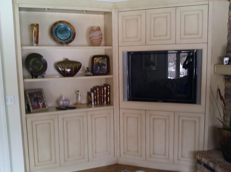 Cream painted corner built-in with display shelves and a TV cabinet
