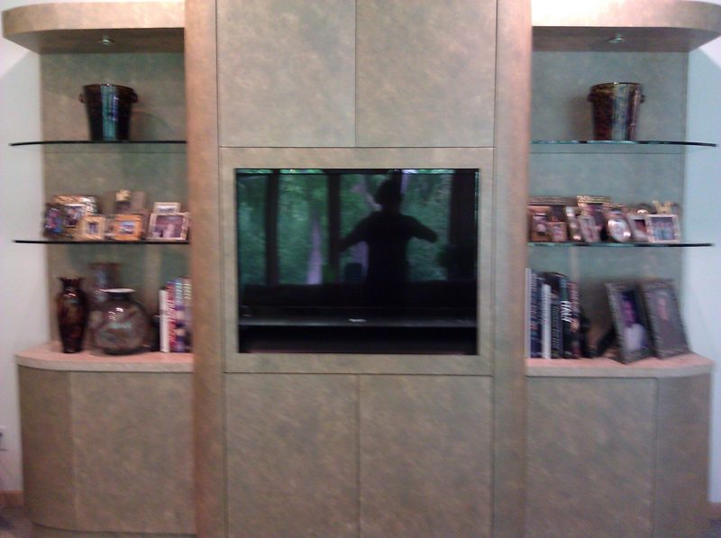 Green faux-finish media wall with a TV and glass side shelves