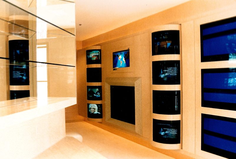 Home theater with a wall of built-in screens framed by curved cream panels
