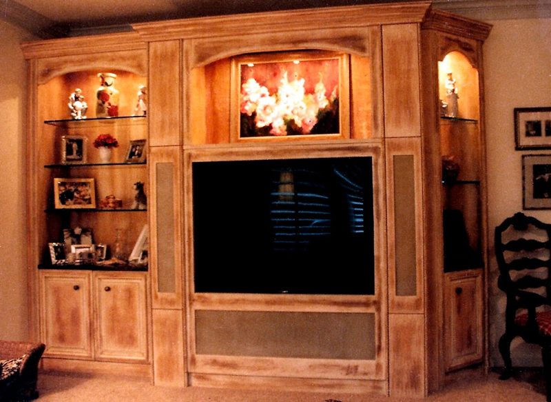 Light distressed wood entertainment center with lit shelves and a TV