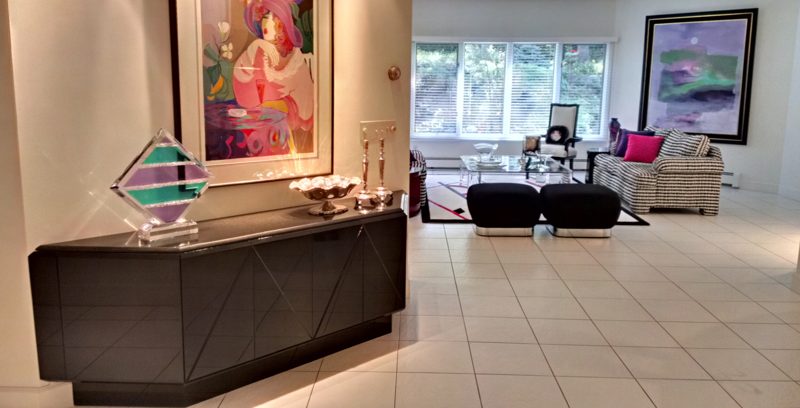Black sideboard in a tiled foyer opening to a living room
