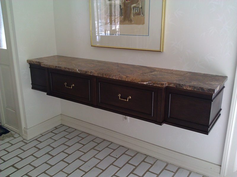 Floating dark wood console with drawers and a marble top