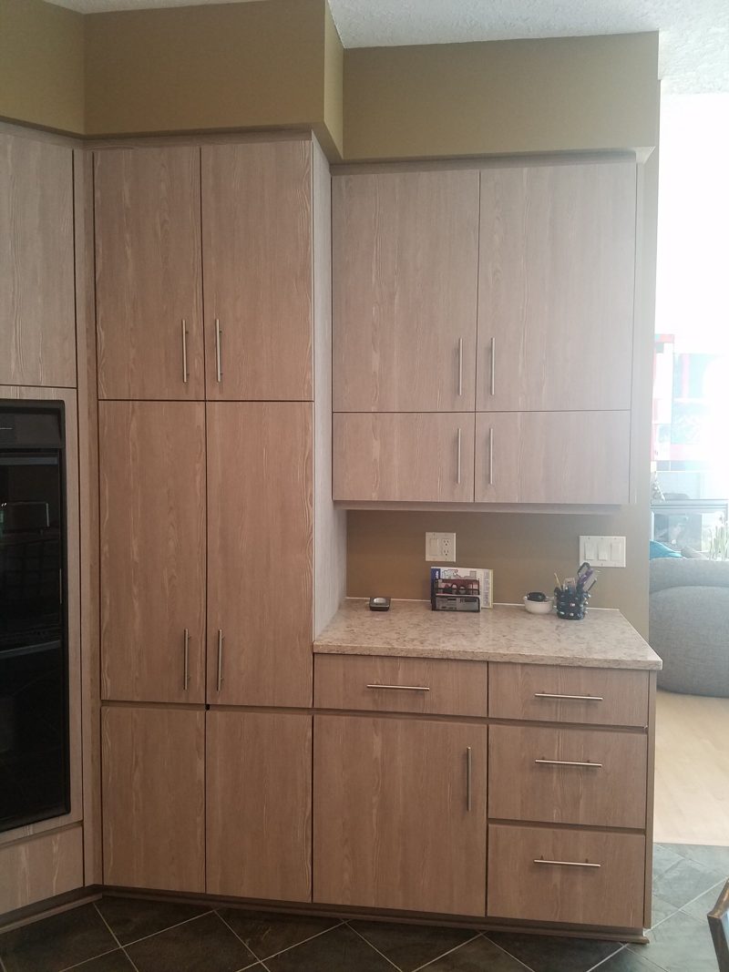 Light oak-grain pantry cabinets and a coffee station with drawers below