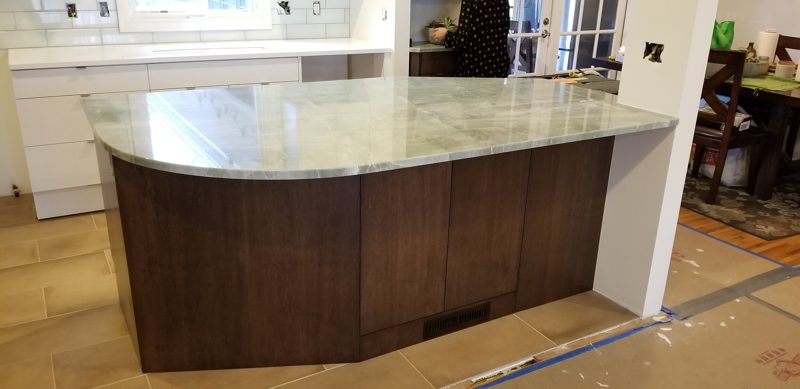 Dark wood island with a pale granite top, before the floor is finished