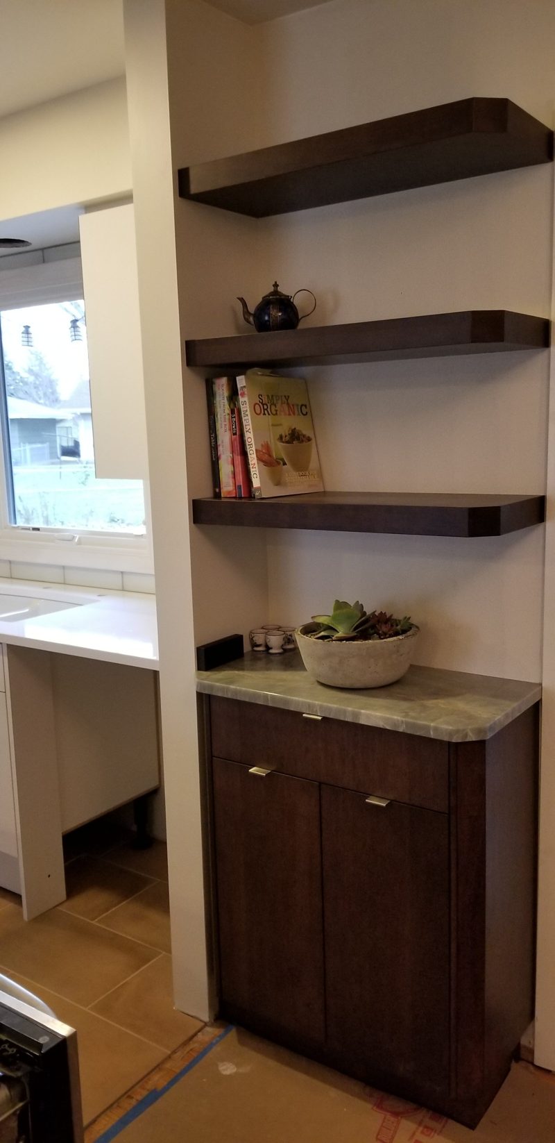 Floating dark wood shelves above a dark wood base cabinet