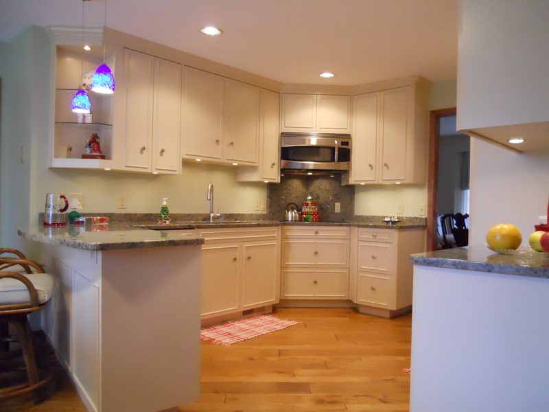 Cream kitchen with glass-front corner cabinets and a granite island