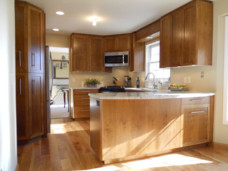 Cherry-toned cabinetry with a tall pantry and a curved island