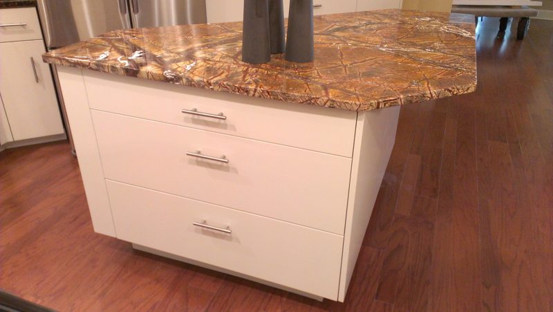 White island with drawers and a red-veined granite top on a wood floor
