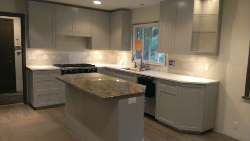 Gray kitchen with a granite island and white counters