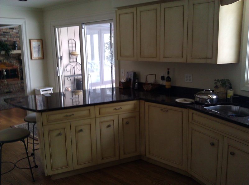 Cream corner cabinets with black granite counters by a patio door