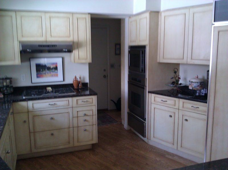 Cream cabinets with black granite, wall ovens, and a range hood
