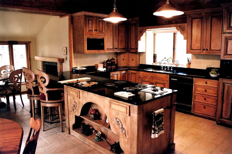 Traditional wood kitchen cabinets and center island with dark stone countertops