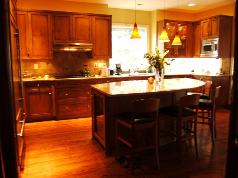 Wood kitchen with an island and pendant lights in warm evening light