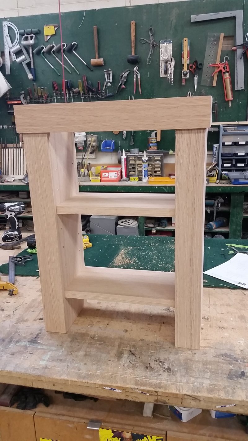 Unfinished light wood end table frame on a workbench