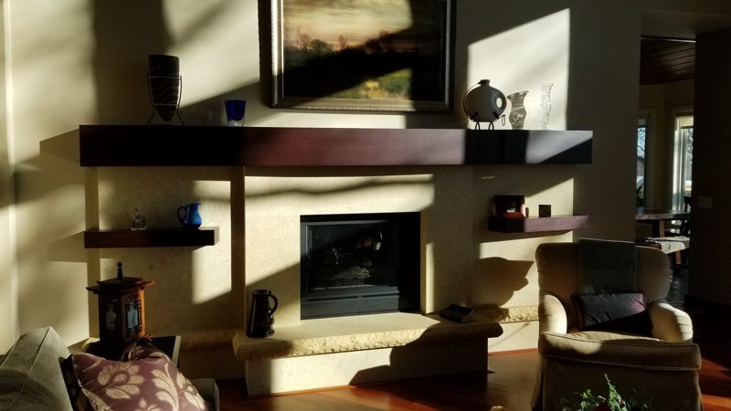 Dark wood floating mantel and shelves around a fireplace